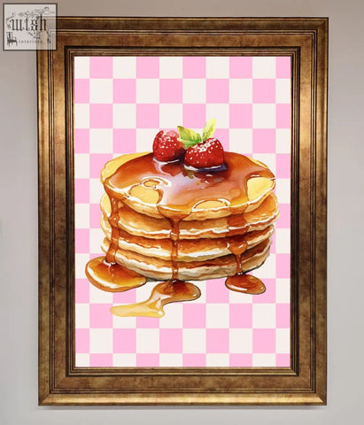 A framed print of syrup pancakes with two strawberries on a pink checkered background with frame choices