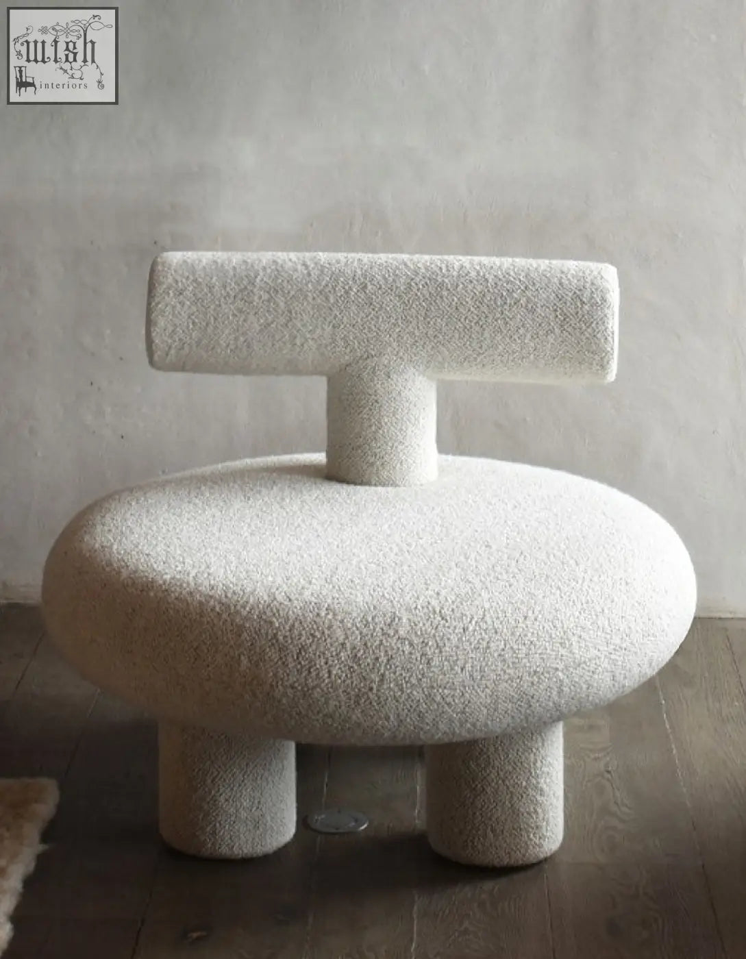 Cream-colored plush shapte sheep armchair with rounded seat and backrest in soft cashmere wool upholstery