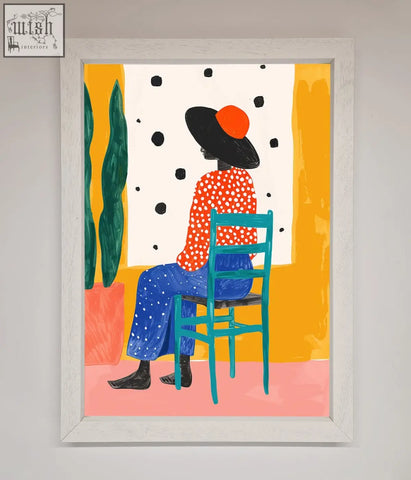 A vibrant take a seat framed poster showing a figure in orange polka dot top and blue pants on a teal chair with frame options