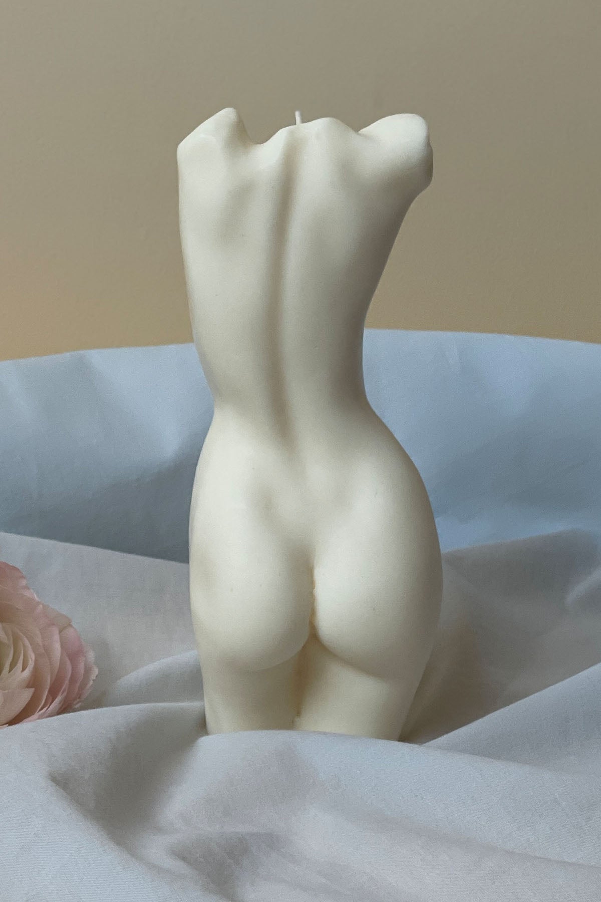 Cream-colored sculpted tall aphrodite body candle showing the back side with 1px solid detailing