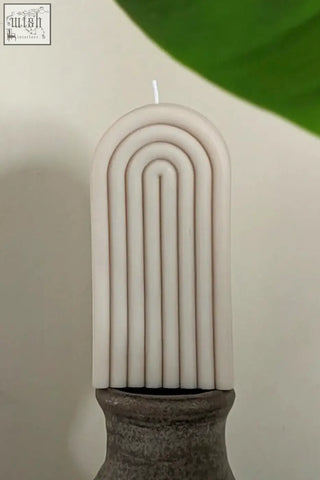 A sleek off-white tall arch candle with modern concentric curved ridges for stylish home decor