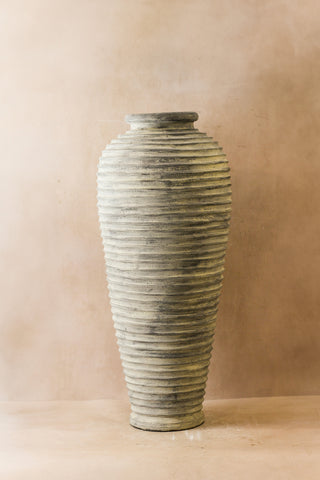 A tall rustic ribbed indonesian pot no 25 xl in gray ceramic with textured horizontal ridges and a flared rim