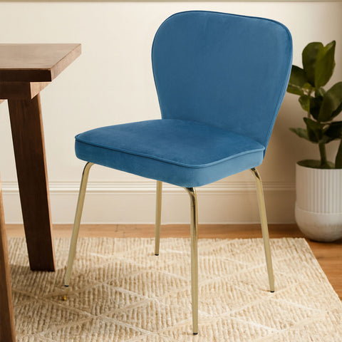 A sleek tamzin blue velvet tapered back dining chair with a blue seat and slender gold-tone metal legs