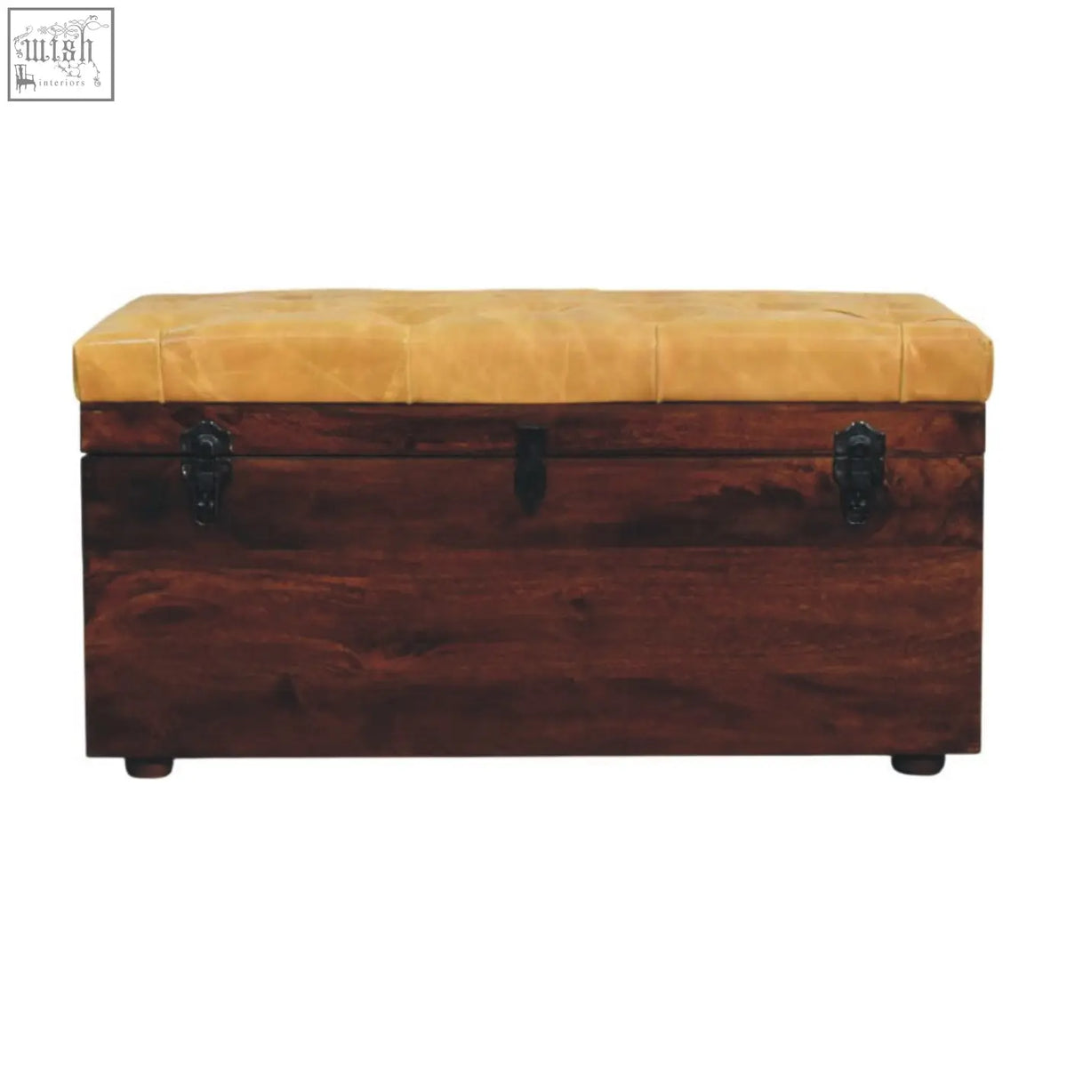 A tufted mustard leather top on a dark wood tan leather storage trunk bench with black metal latches