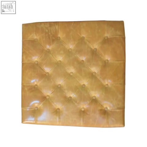 Tan leather upholstered ottoman with a golden tufted leather headboard featuring diamond-patterned stitching and glossy finish