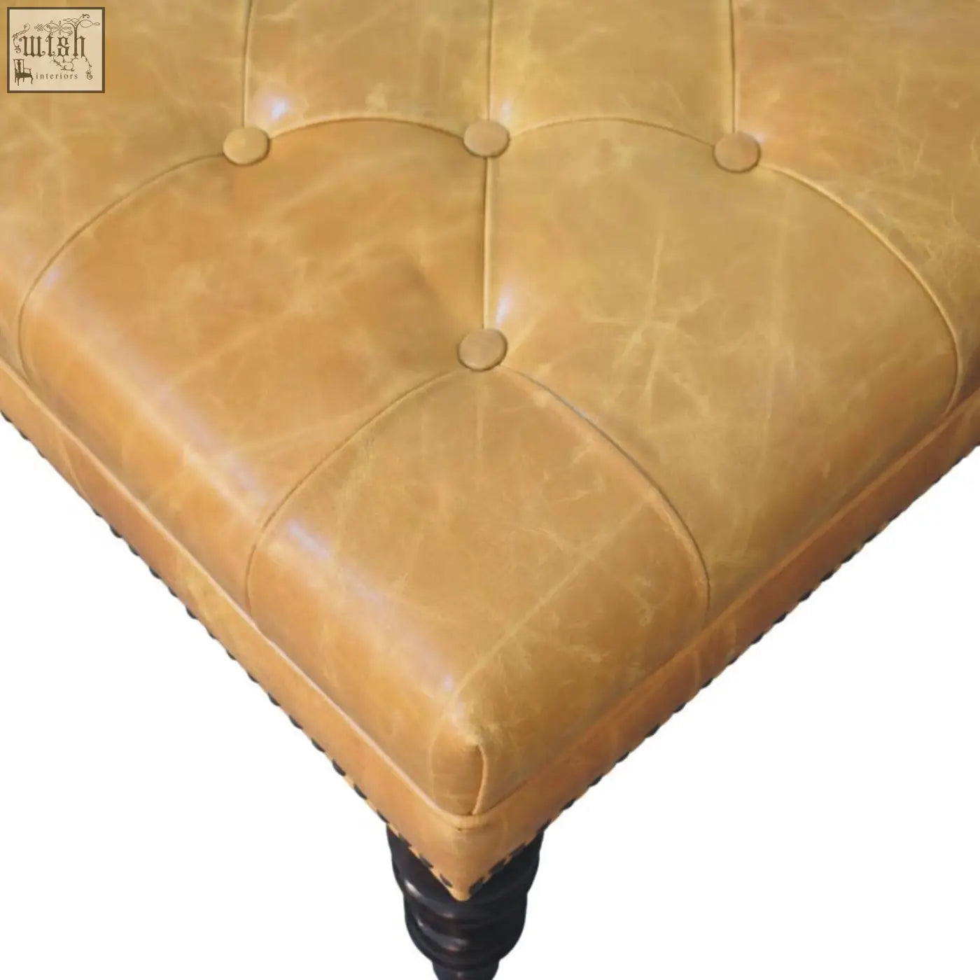 Tan leather upholstered ottoman with tufted button detailing and dark wooden legs for stylish seating or storage