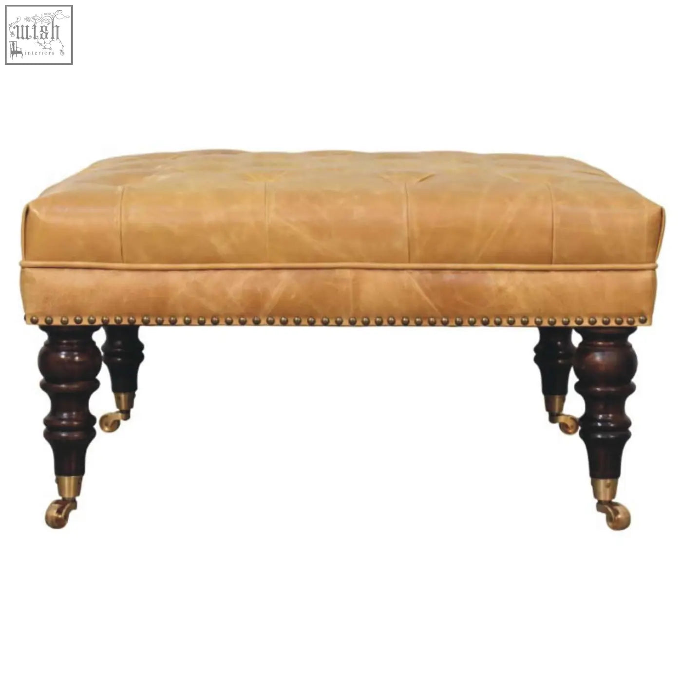 Tan leather upholstered ottoman with tufted top dark wood legs and brass casters for stylish living room seating