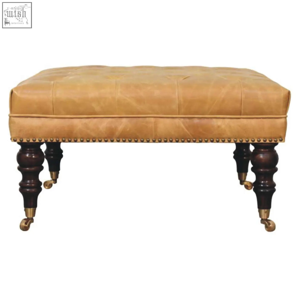 Tan leather upholstered ottoman with tufted top dark wood legs and brass casters for stylish living room seating
