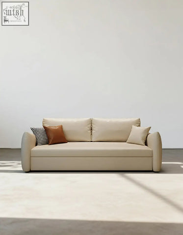 Beige leather tanak two seater sofa bed with rounded arms brown pillow and black and white checkered throw