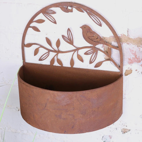 Rustic tanu wall mounted metal planter with cut-out leaf and branch design in a rusted finish for outdoor use