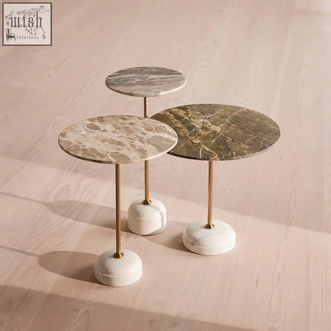 Three elegant tarantino side tables with beige and green marble tops on stainless steel gold-toned legs and white bases