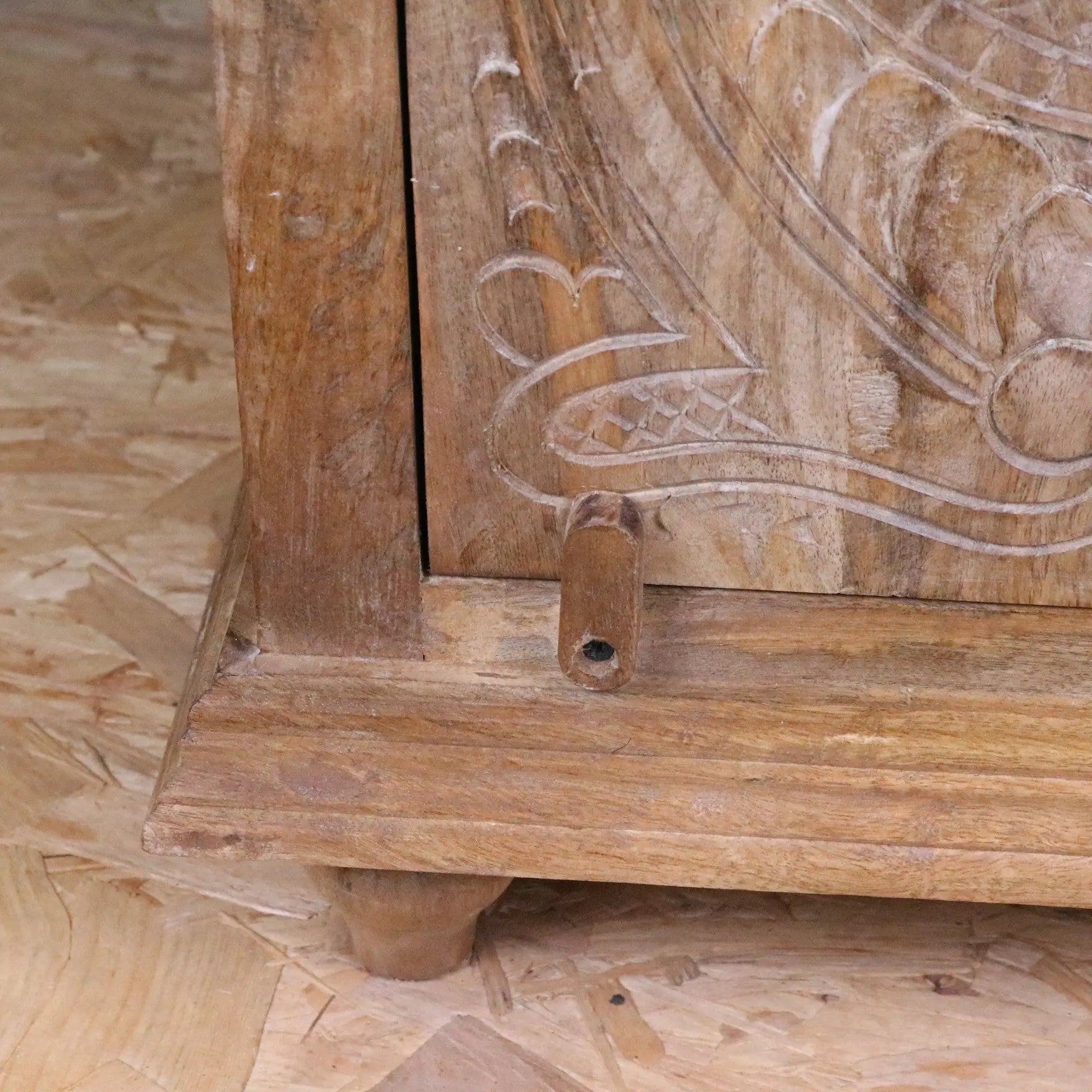Tarinda hand-carved wooden storage cabinet with intricate floral scrollwork and natural light brown finish wood grain visible