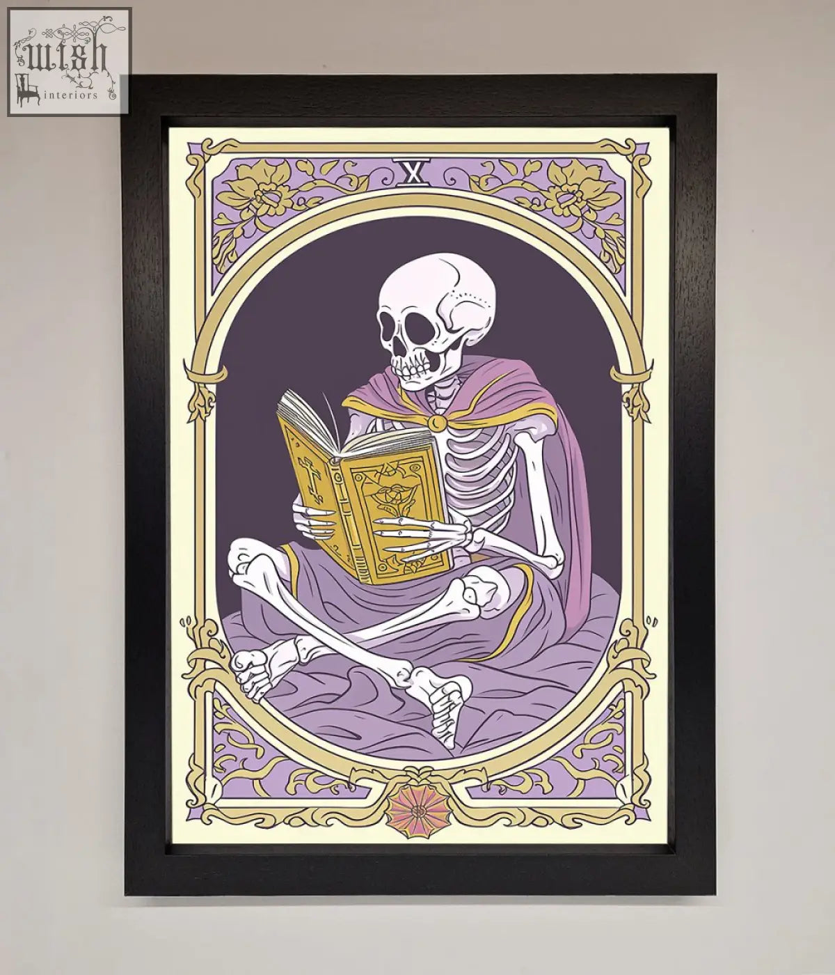 A framed print of a tarot skeleton reader in a purple robe holding an ornate book with gold and lavender floral border