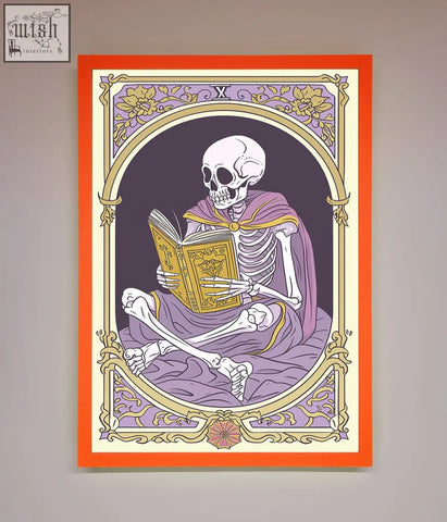 A framed print of a tarot skeleton reader in a purple robe reading an ornate book with an orange gold border