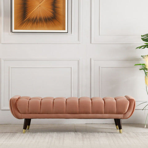 A plush rose-pink velvet tb15 orange bench with tufted upholstery and dark wood tapered legs with gold tips