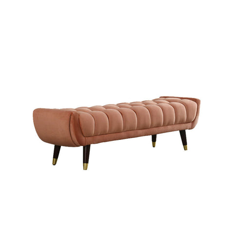 A sleek tb15 orange bench with rose gold velvet tufted upholstery and tapered black legs with brass tips