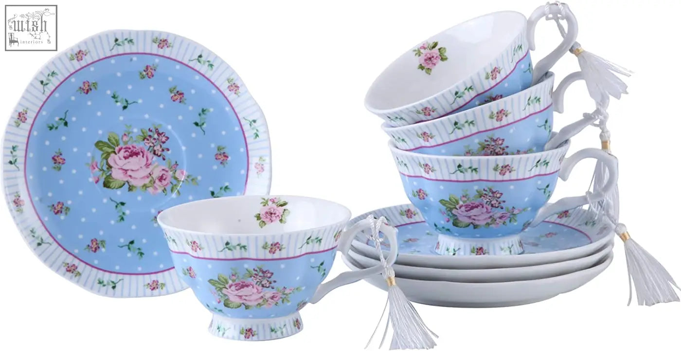 Light blue porcelain teacup and saucer with pink rose design and white tassels part of tea set with milk jug and sugar bowl gift box