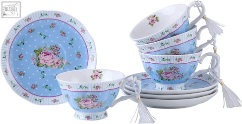 Light blue porcelain teacup and saucer with pink rose design and white tassels part of tea set with milk jug and sugar bowl gift box