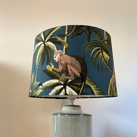 Navy blue french drum lampshade with jungle monkey cotton print featuring a detailed monkey among palm trees