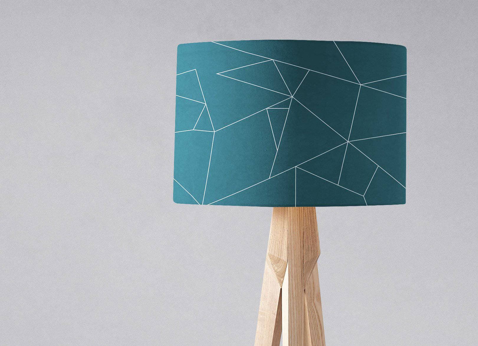 Teal table lamp with white line geometric design and light wood tripod lamp base perfect for ceiling or table use