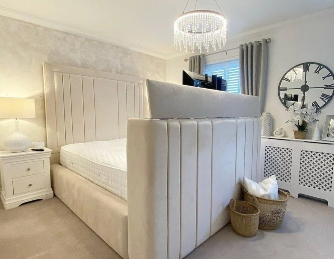Cream-colored upholstered telly bed with vertical tufted panels and built-in headboard fits tvs small double