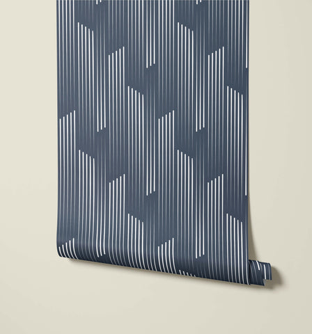 A roll of tempest navy blue wallpaper with a modern white vertical line geometric pattern