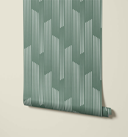 A roll of tempest wallpaper in muted sage green with white vertical geometric lines for modern wall decor