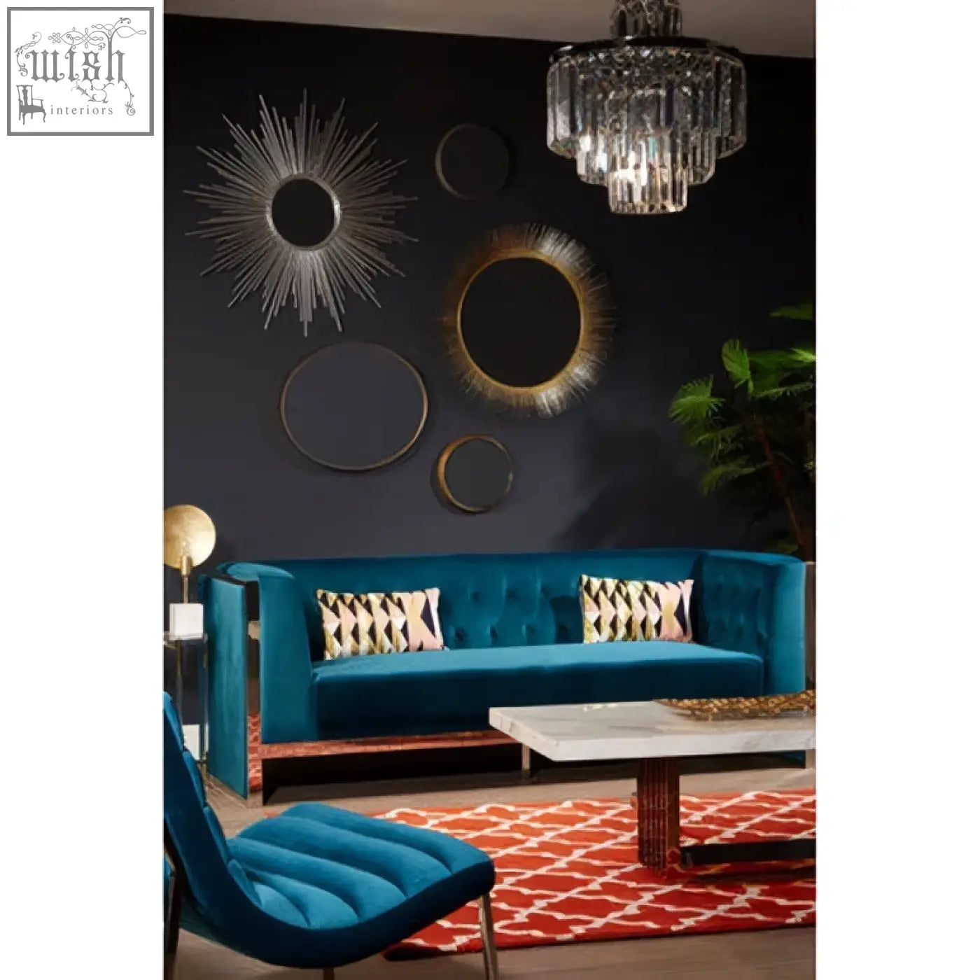 Teal velvet sofa with tufted back and gold-tone metal legs next to templar brass finish wall mirror with brass finish frame