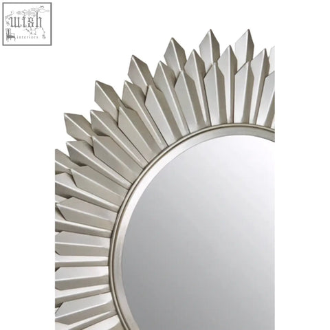 Templar sunburst wall mirror with silver faceted pointed rays radiating from a circular reflective center