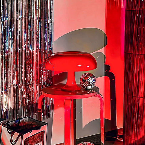 Vibrant red ambient mushroom desk lamp with glossy finish sits on matching stool for stylish ambient lighting
