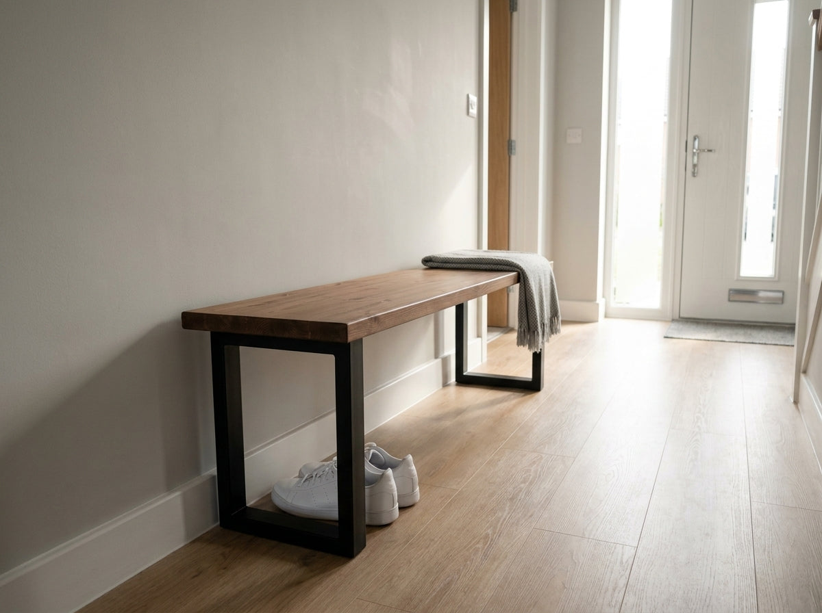 The bruton bench walnut is a minimalist wooden bench with black metal legs and a gray throw from the bruton range