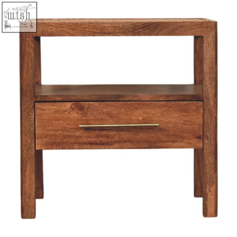 A minimalist caldera bedside stand with honey caramel finish, wooden drawer, sleek brass handle, and open shelf storage