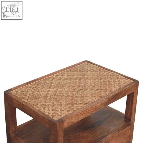 A rustic caldera bedside stand with a honey caramel woven cane top and open shelf in dark brown finish