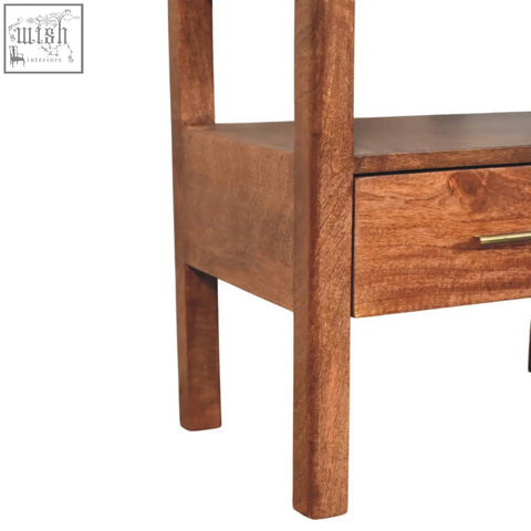 A rustic caldera bedside stand with honey caramel finish, open shelf, single drawer, brass handle, and sturdy legs