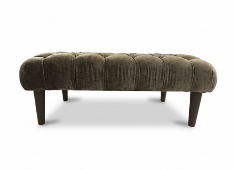 The chester foot stool is a plush olive green velvet tufted bench with dark wooden legs perfect for any room