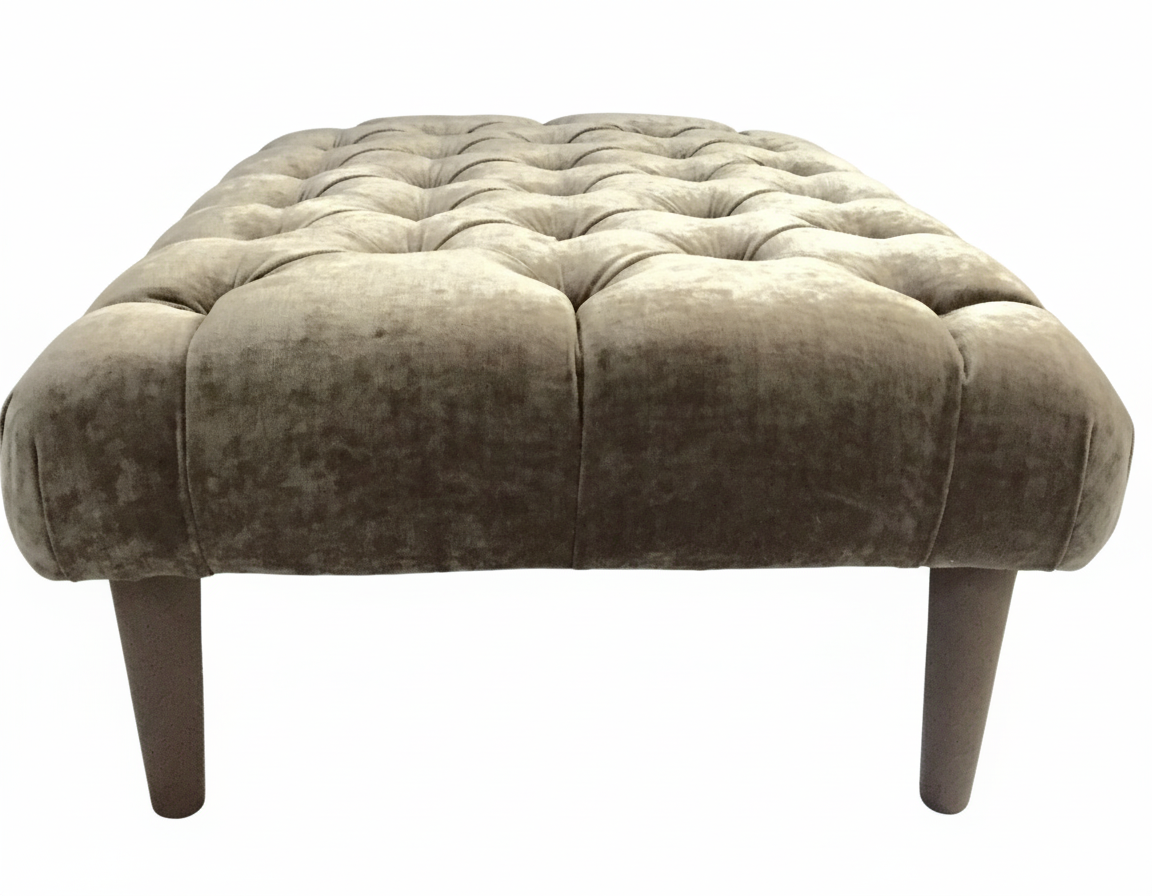 The Chester Foot Stool is a taupe velvet tufted ottoman with dark wooden legs perfect for living room seating