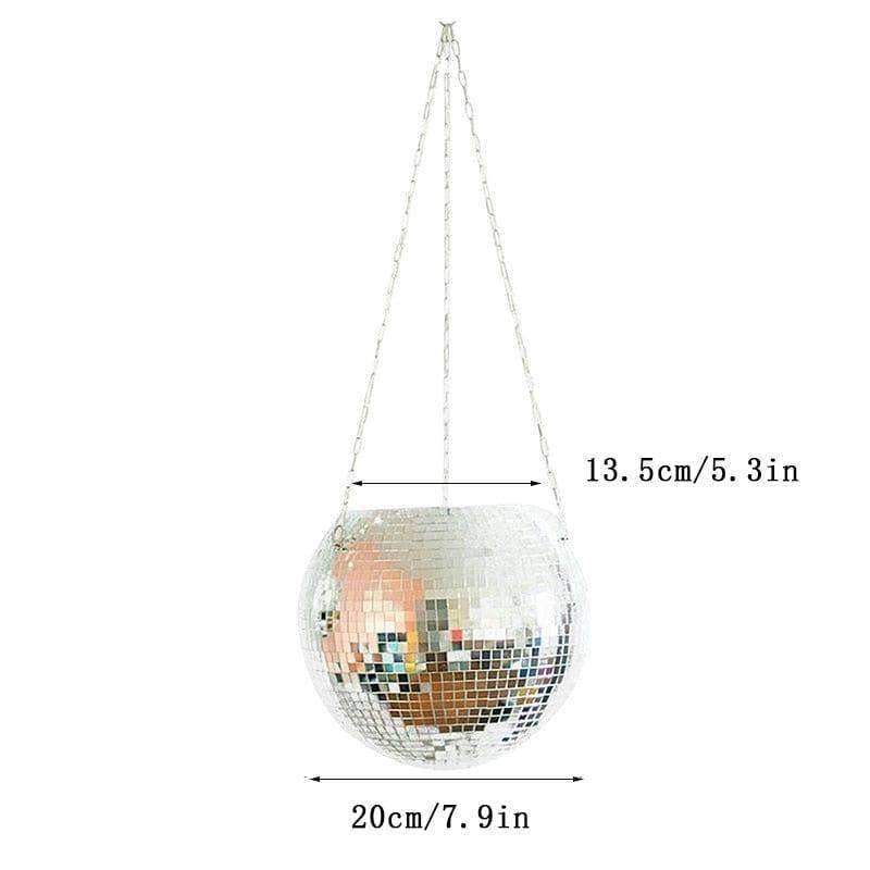 The disco planer is a silver mirrored mosaic disco ball planter hanging by silver chains for stylish plant display