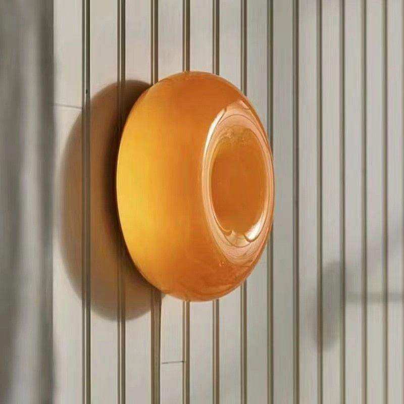 A translucent orange circular wall-mounted soap dish with a glossy finish inspired by the donut lamp design