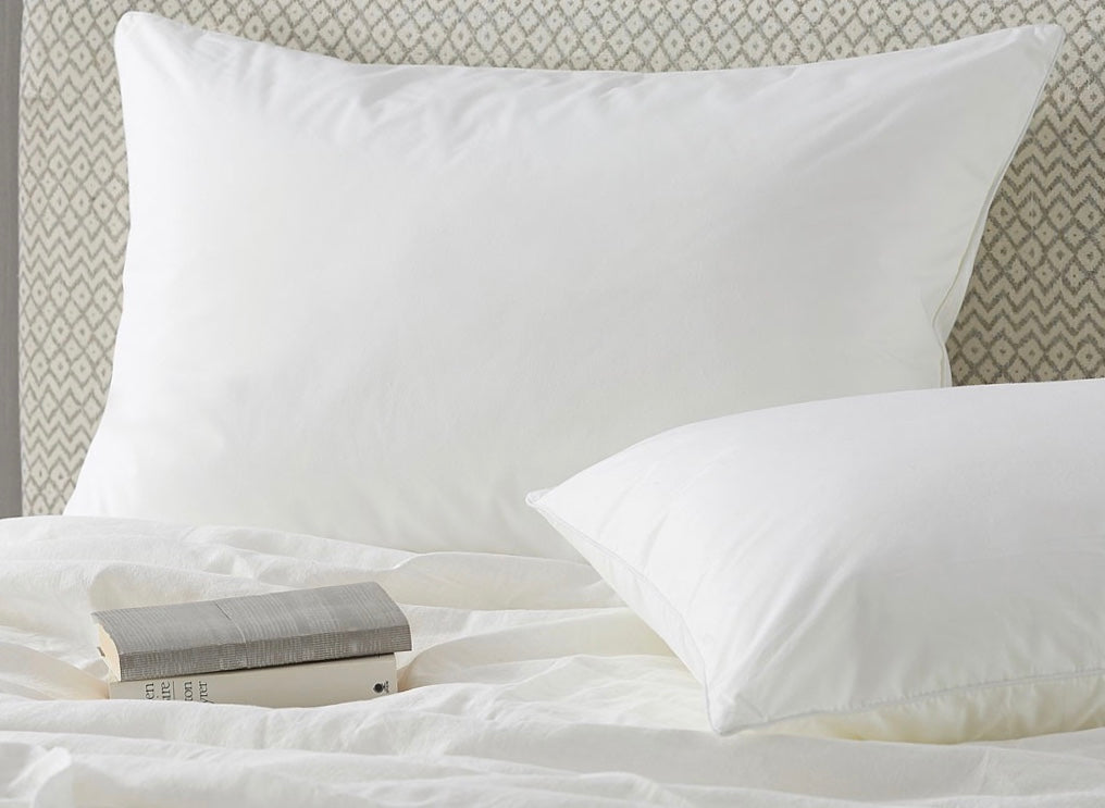 White duck down surround pillow with central chamber features white cotton pillowcases with subtle sheen on bed