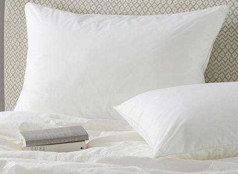 White duck down surround pillow with central chamber features white cotton pillowcases with subtle sheen on bed