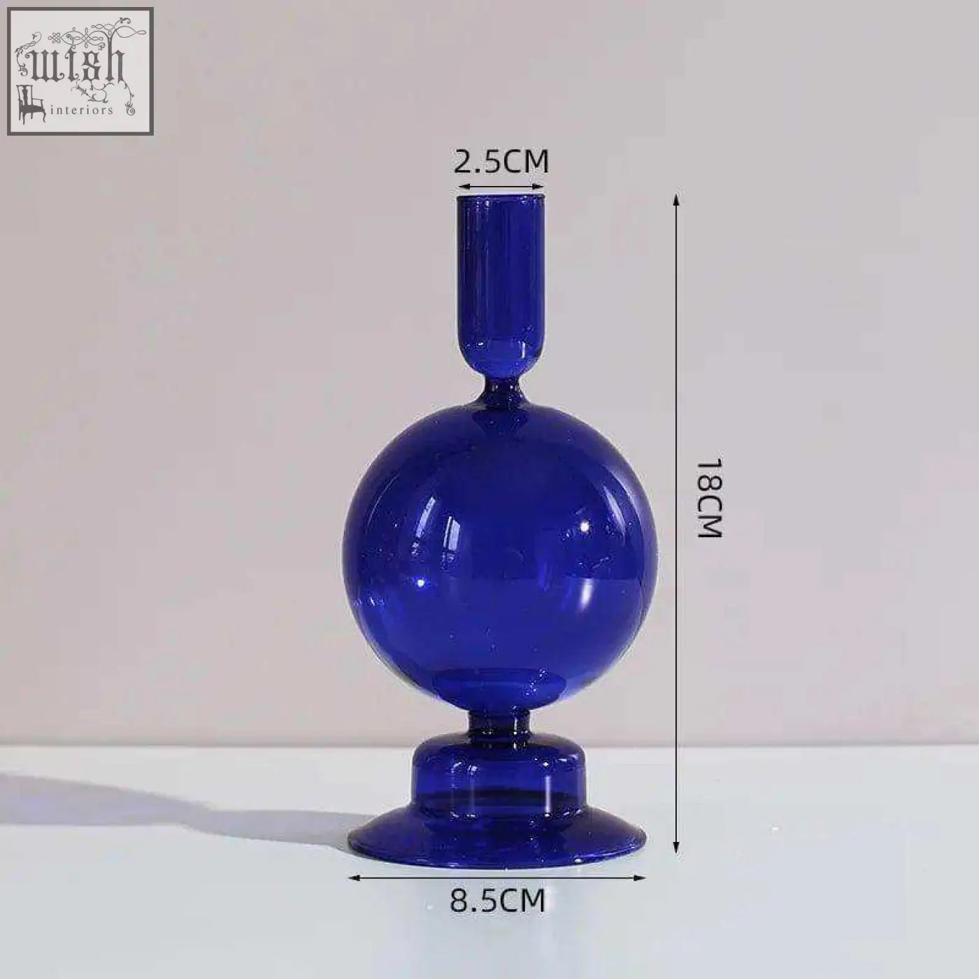 The glass candle holder is a sleek cobalt blue glass candle with a rounded bulbous body and slender neck