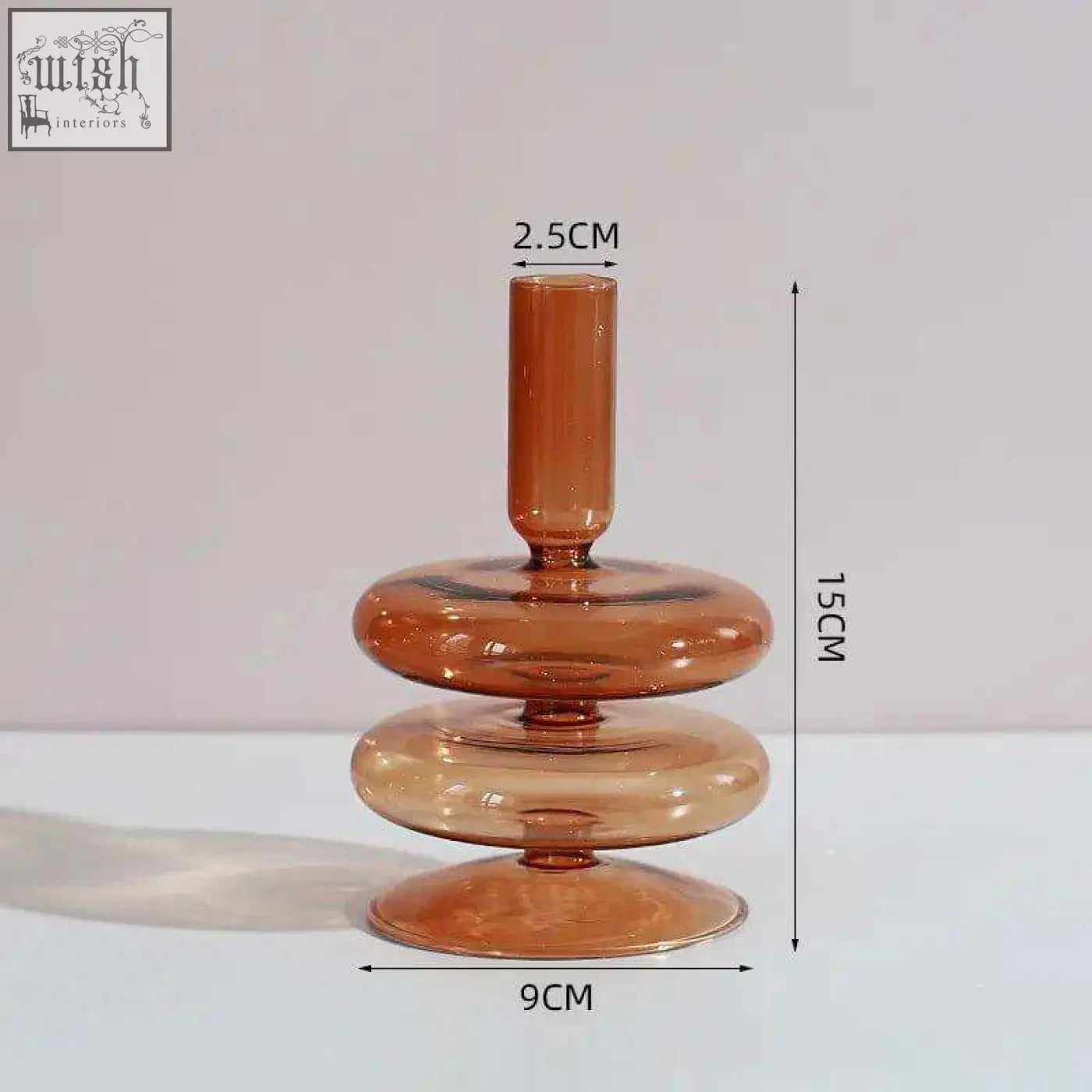 A sleek amber glass candle holder with a modern tiered design featuring three stacked rings and a slender top