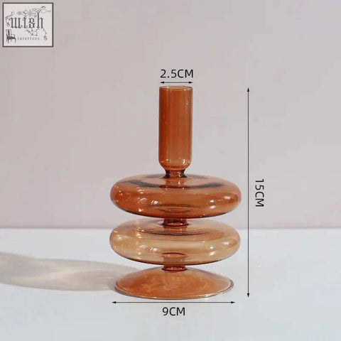 A sleek amber glass candle holder with a modern tiered design featuring three stacked rings and a slender top
