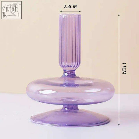 A translucent lavender glass candle holder with a fluted stem and rounded base perfect for holding glass candles