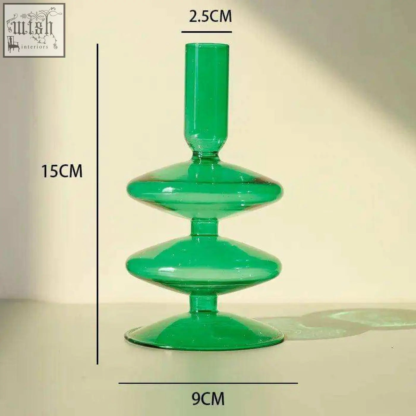The glass candle holder is a translucent emerald green glass candle holder with a modern tiered design and stacked discs
