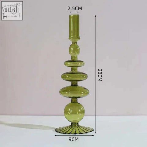 A tall translucent olive green glass candle holder with tiered stacked spherical and oval segments for candles