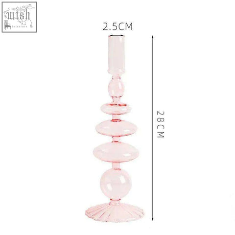 A delicate pink glass candle holder with a tiered bulbous design and fluted base perfect for candles