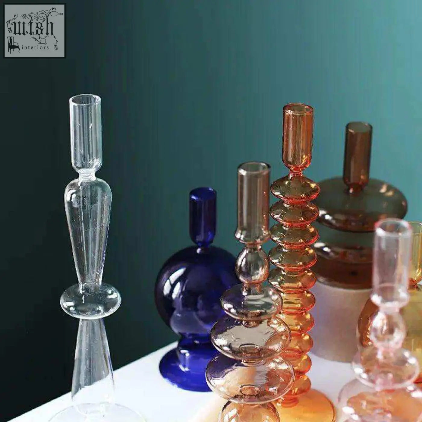 A collection of colorful translucent glass candle holders with unique stacked bulbous designs for candles