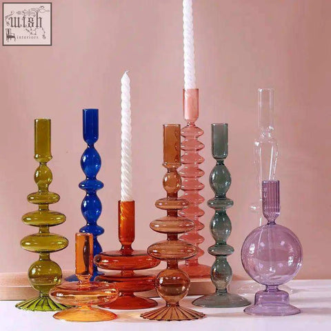 A collection of colorful translucent glass candle holders in various shapes perfect for any glass candle setup