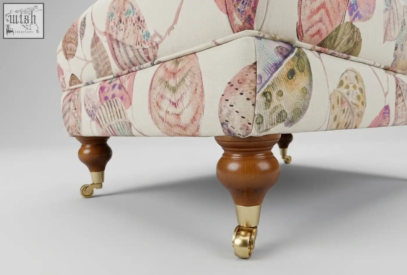 The highland foot stool is a cream upholstered footstool with shell patterns, solid wood frame, high density foam, and leg options